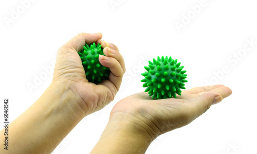 hand with Spiny plastic green massage ball isolated on white