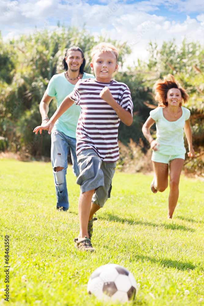 Naklejka premium boy with happy parents playing in soccer