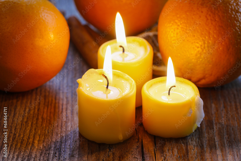 Beautiful candles and juicy oranges on jute table cloth Beautiful candles and juicy oranges on jute table cloth