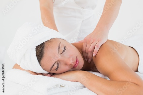 Attractive woman receiving shoulder massage at spa center