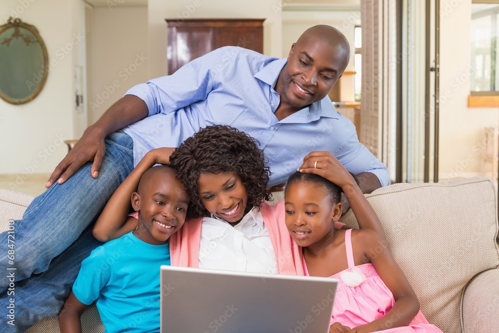 Happy family relaxing on the couch using laptop Happy family relaxing on the couch using laptop