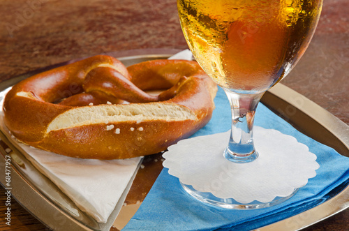 close-up of cold beer in a glass with pretzel