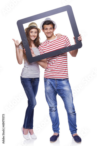 Happy couple looking through tablet frame photo