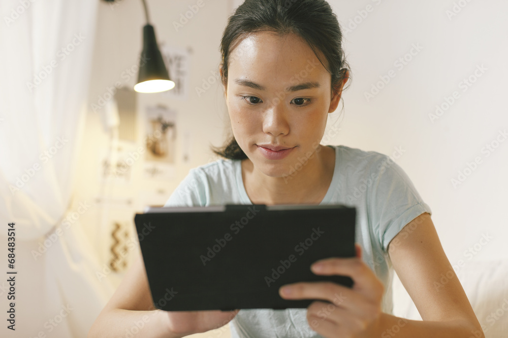 Asian woman lying on bed and using digital tablet in the night. Asian woman lying on bed and using digital tablet in the night.