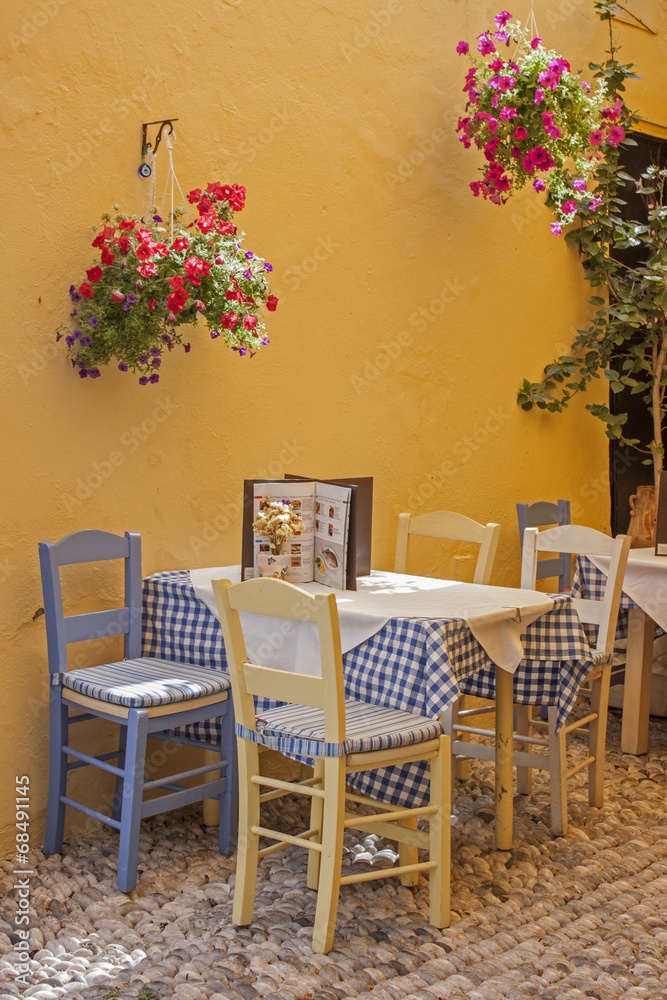 a typical Greek taverna with tables and straw chairs