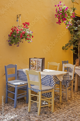 a typical Greek taverna with tables and straw chairs © xiaoma
