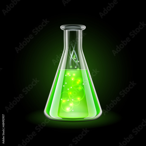 Transparent flask with magic green liquid on black background.