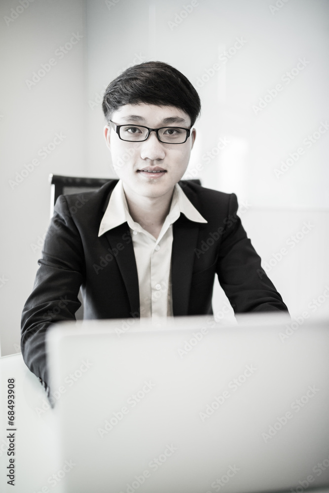 Young handsome man using laptop in his office Young handsome man using laptop in his office