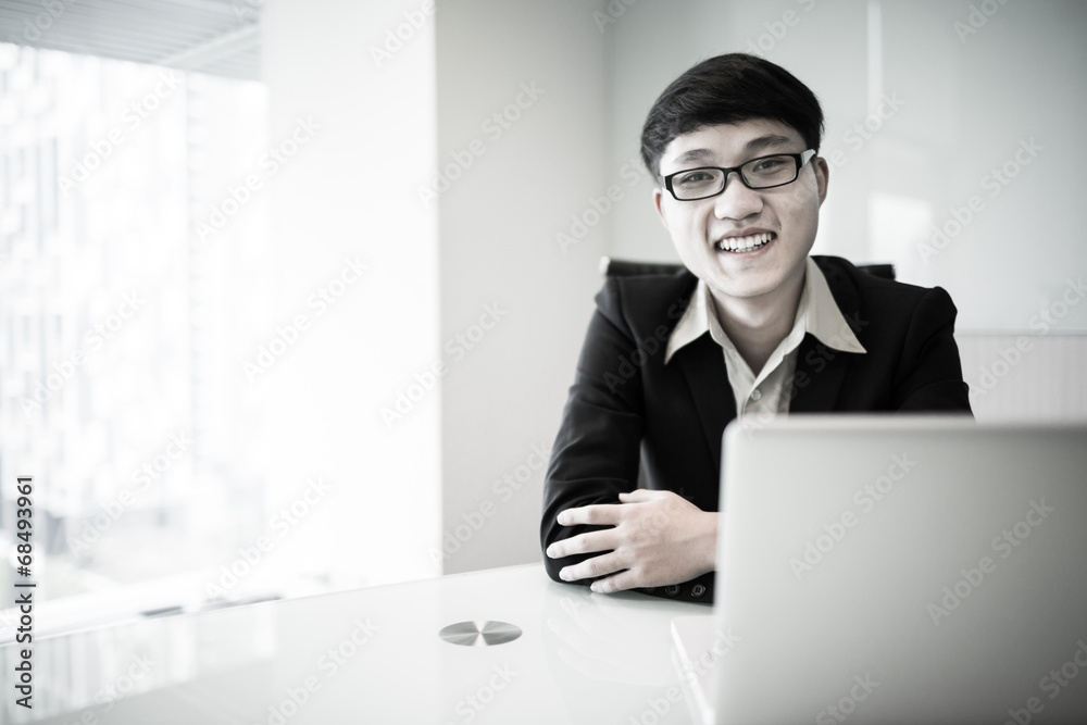 Young handsome man using laptop in his office Young handsome man using laptop in his office