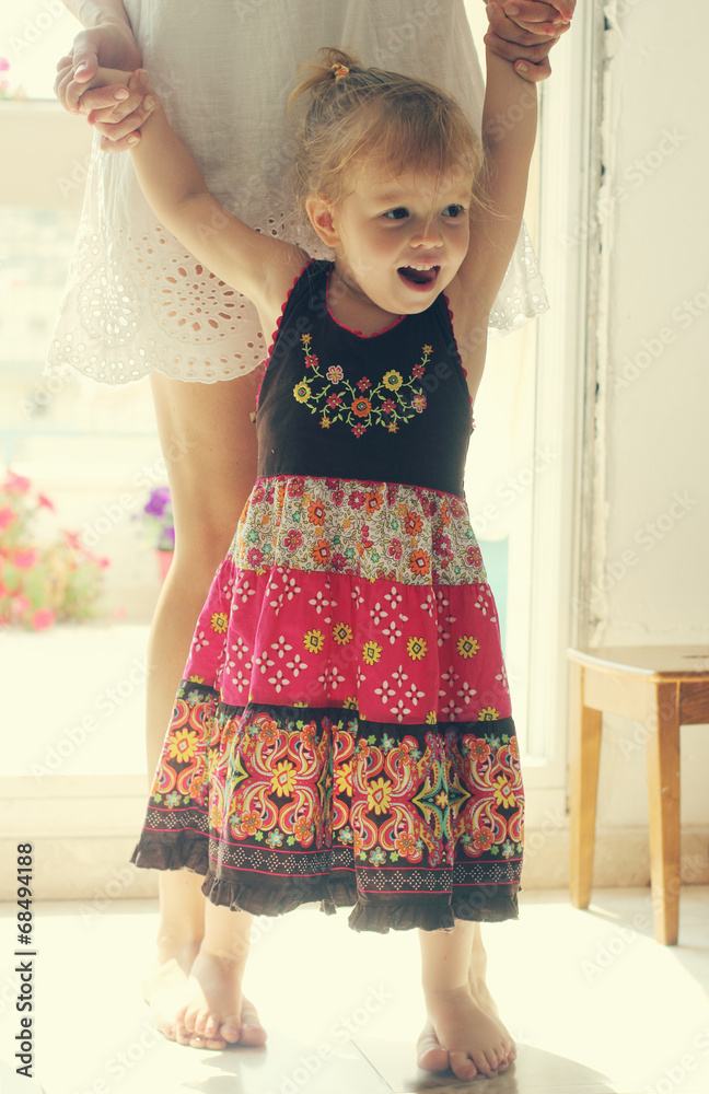 beautiful mother and daughter standing near the window beautiful mother and daughter standing near the window