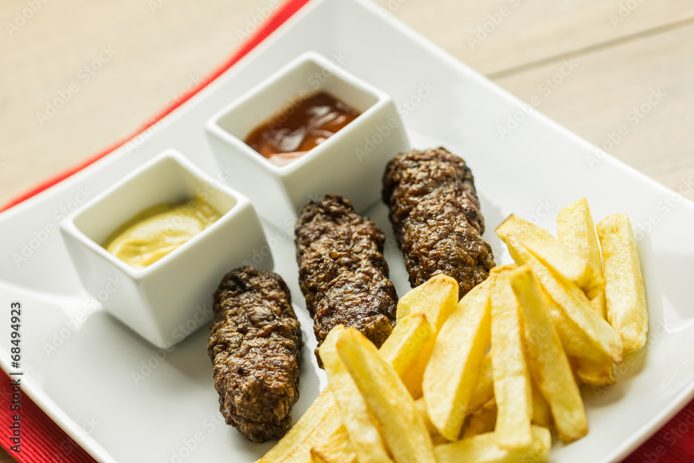 Traditional Romanian Mici And Fries With Ketchup And Mustard