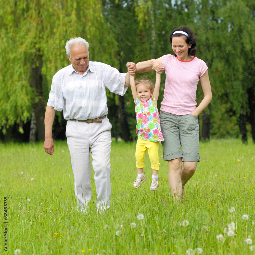 Fototapeta premium family of three generations walking in the park