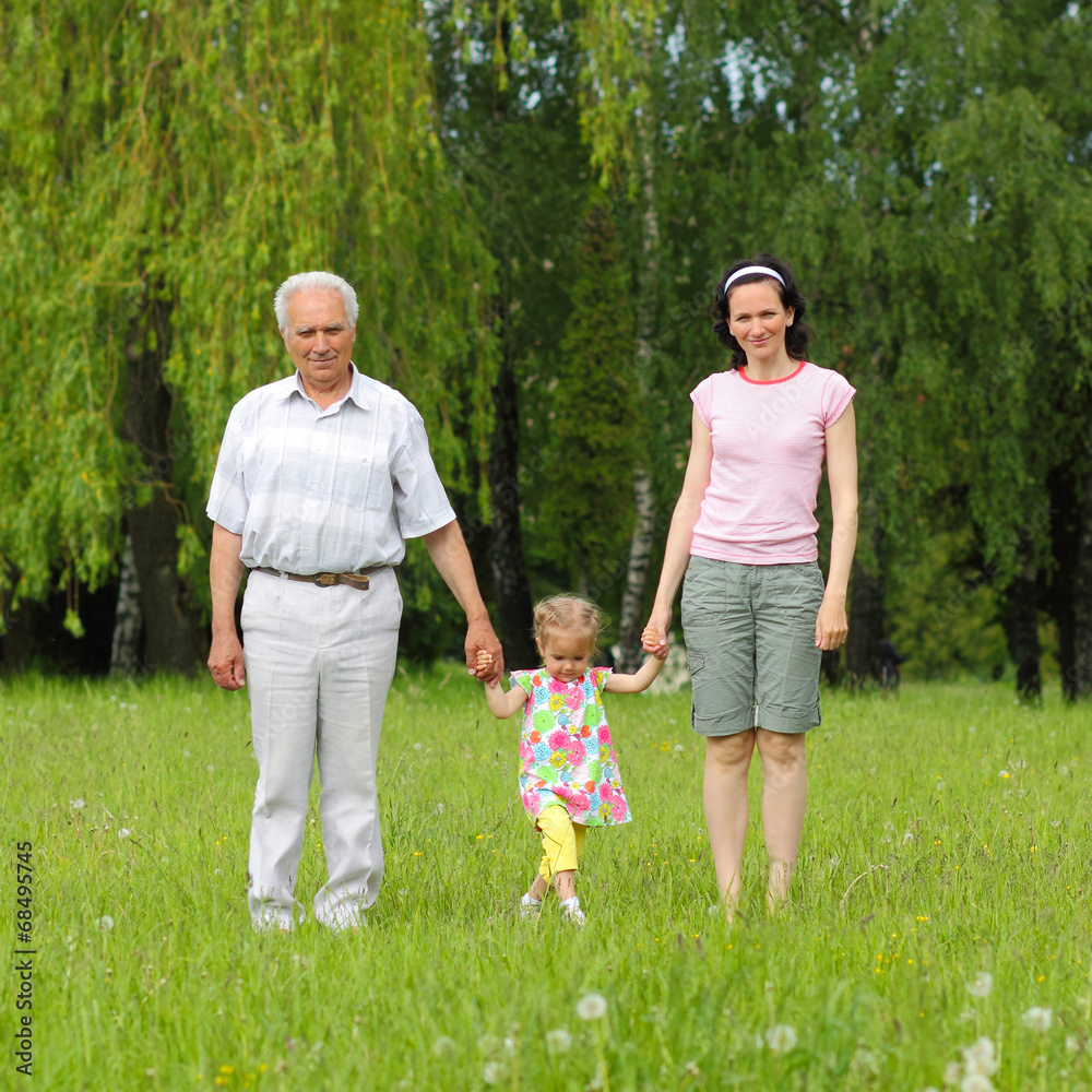 family of three generations walking  in the park