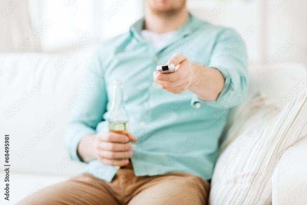 man with beer and remote control at home man with beer and remote control at home