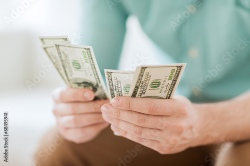 close up of man counting money at home