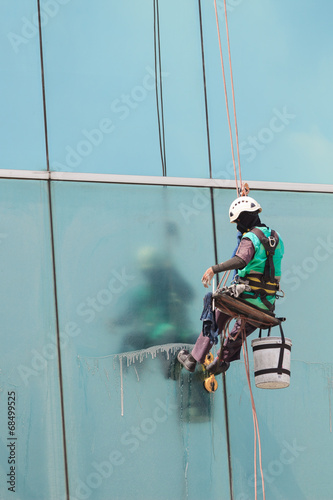 A worker cleaning windows service on high rise building