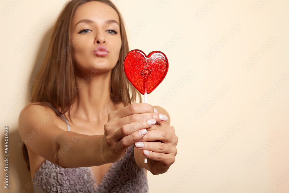 Lovely woman smiling covers one eye lollipop red heart Lovely woman smiling covers one eye lollipop red heart