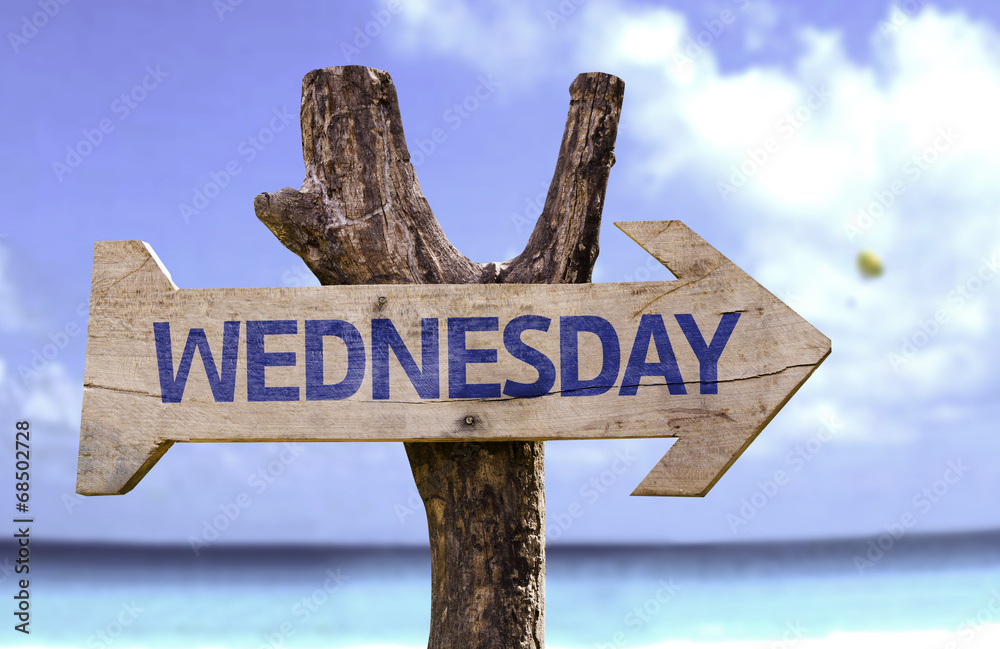 Wednesday wooden sign with a beach on background