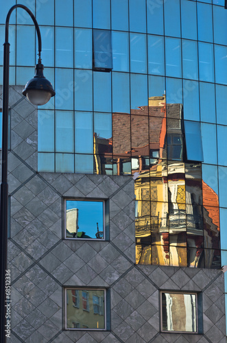 Photography Reflection of old style buildings in a glass of Haas house