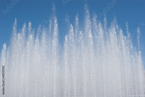 Fountain jet on blue sky background