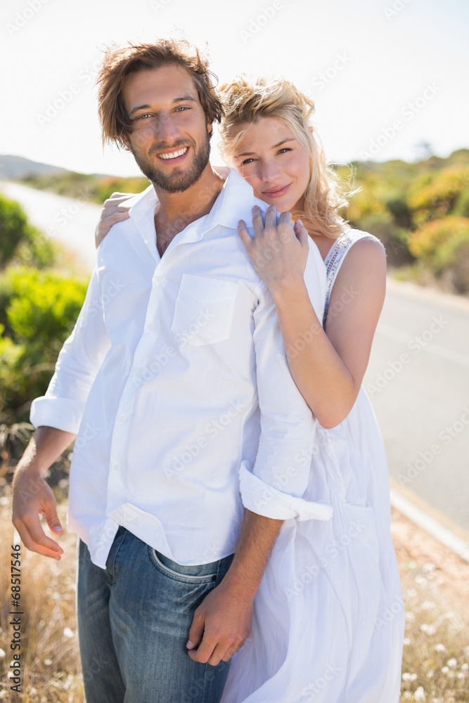 Obraz premium Attractive couple smiling at camera road side