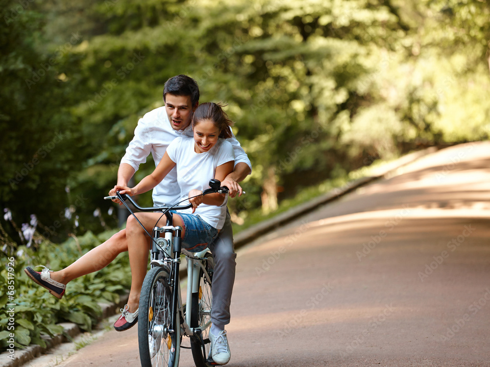 Happy couple cycling in the summer park Happy couple cycling in the summer park