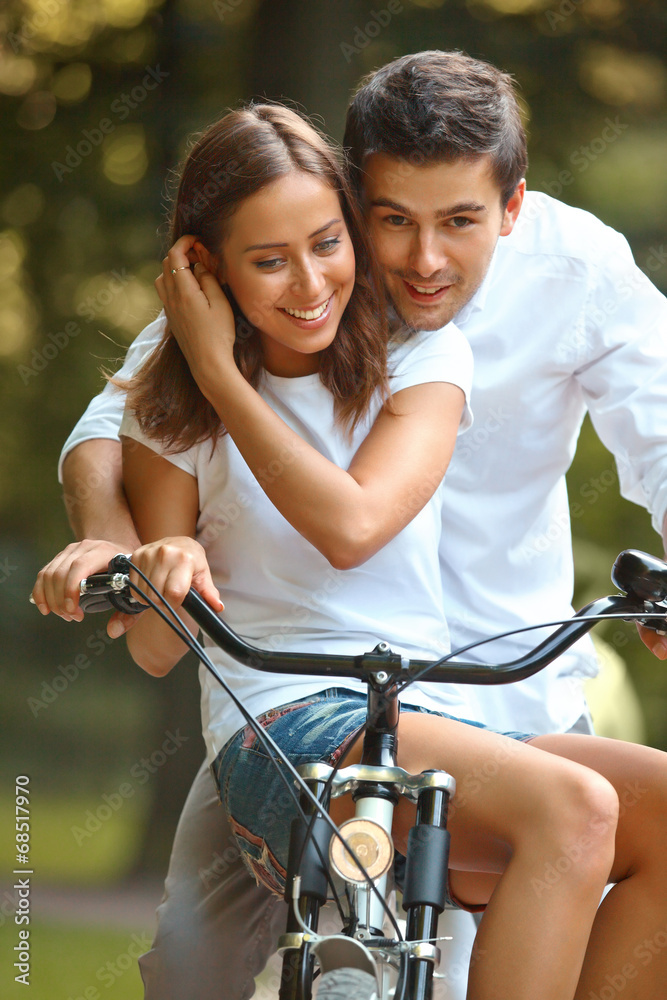 Obraz premium Happy couple cycling in the summer park