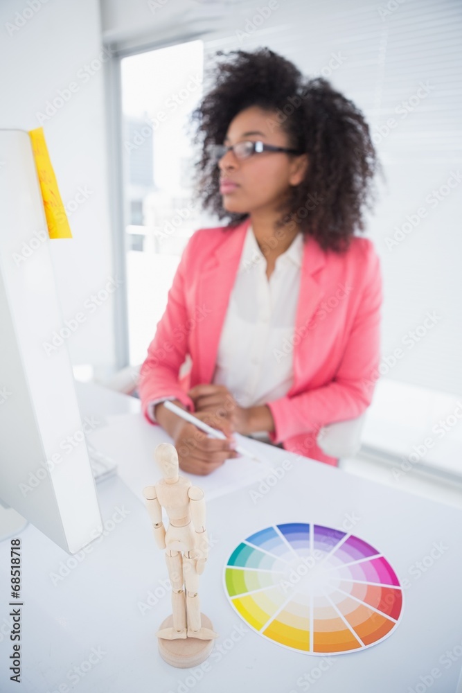 Casual graphic designer working at her desk sketching Casual graphic designer working at her desk sketching