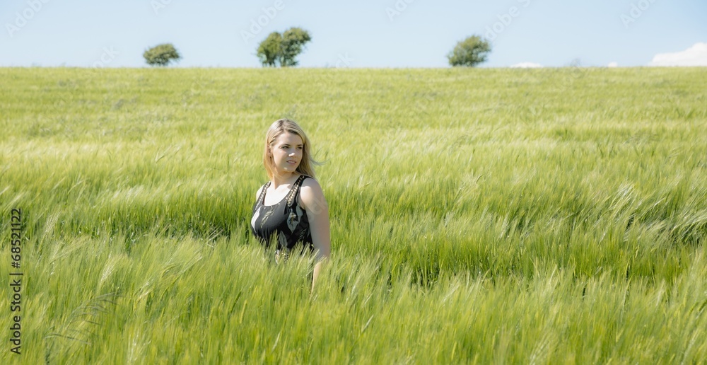 Pretty blonde in sundress standing in wheat field Pretty blonde in sundress standing in wheat field