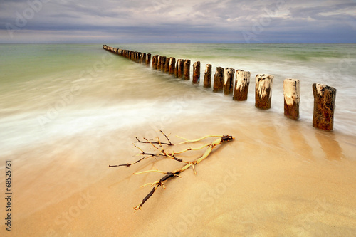 Piękna piaszczysta plaża z drewnianym falochronem