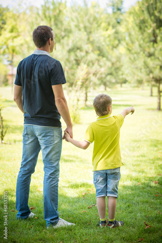 Cheerful father and his son against park