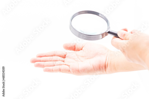 Magnifying glass and hand.