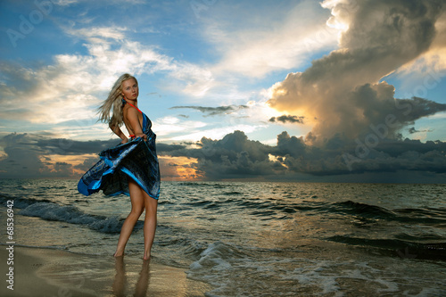 Model posing in beach dress at early morning sunrise