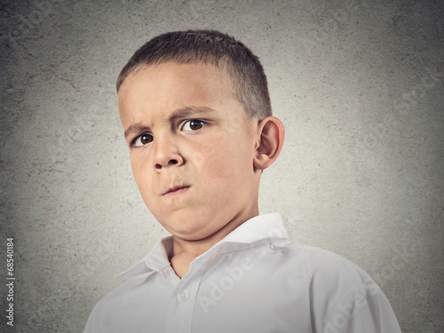 Suspicious boy, full of skepticism isolated grey wall background
