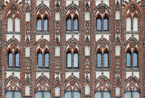 Facade of a historic city center building in the style of brick gothic with many windows. This architectural style was used from the 12th to the 16th century