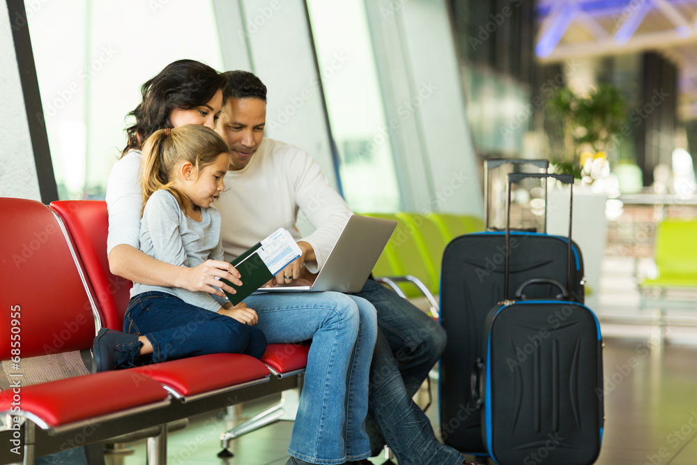 © michaeljung - parents and daughter using laptop at airport