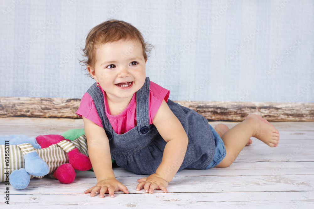 Naklejka premium Happy little child playing on the floor