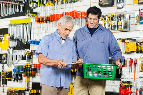 Father And Son Buying Tools In Hardware Store