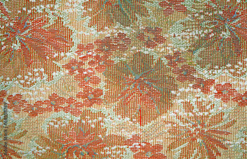 Texture of the old tapestry fabric with faded red floral pattern