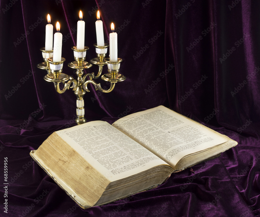 Candelabra with open old Bible StockFoto Adobe Stock