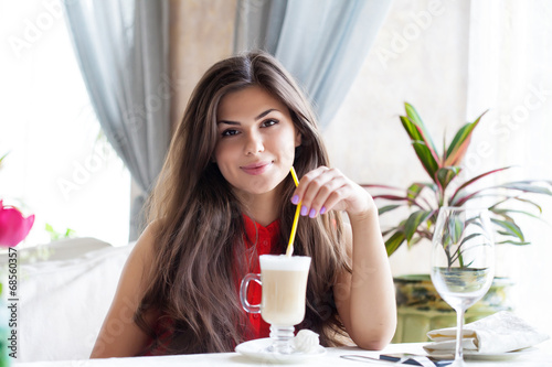 A woman in a restaurant is drinking cocktail photo