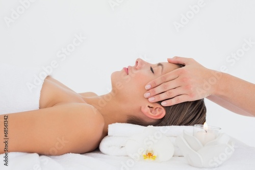 Attractive young woman receiving head massage at spa center