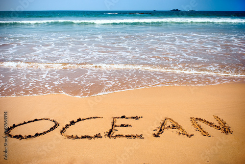 ocean handwritten inscription in sand on a beach