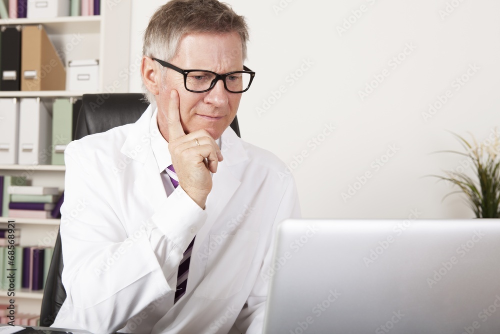 Medical Specialist Seriously Reading at Computer Medical Specialist Seriously Reading at Computer