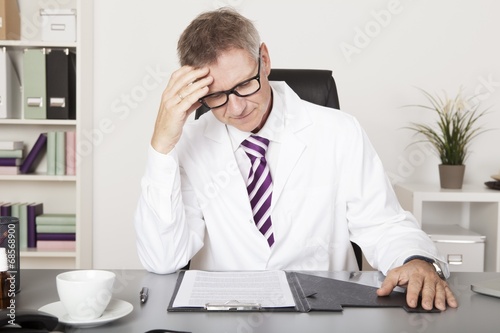 Doctor Reading Records While Having Coffee