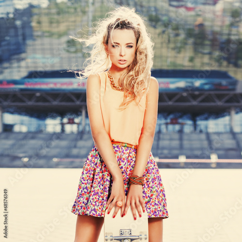 beautiful young lady with a skateboard with blank deck