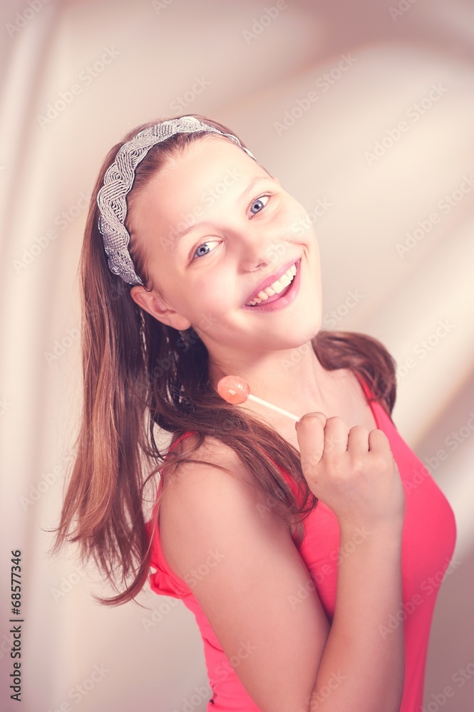 Happy teen girl holding lollipop