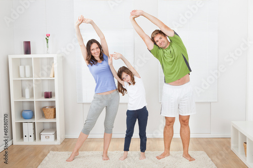 Portrait Of Fit Family Performing Yoga