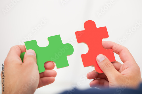 Man Joining Puzzle Pieces
