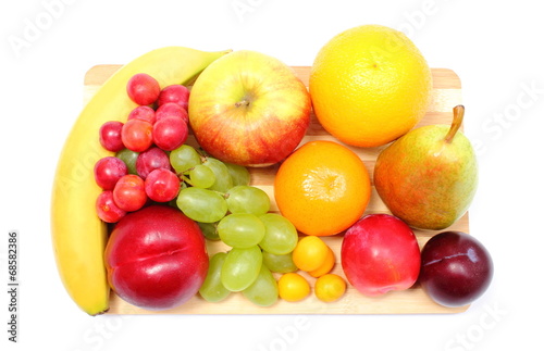 Fresh ripe fruits on wooden cutting board